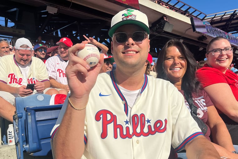 Phillies fan Michael Neill holds the Kyle Schwarber home run ball he caught in the first inning of Game 1 of the NLDS against the Mets at Citizens Bank Park.