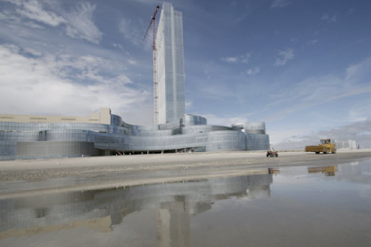 A bulldozer at the Revel casino construction site in Atlantic City fortifies a dune. Revel, to open in May, is partnering with agencies to prevent erosion. (Elizabeth Robertson / Staff Photographer)