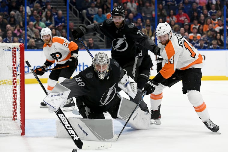Tampa Bay Lightning goaltender Andrei Vasilevskiy (88) knocks the puck away as Flyers center Sean Couturier (14) looks for a shot during the first period Saturday.