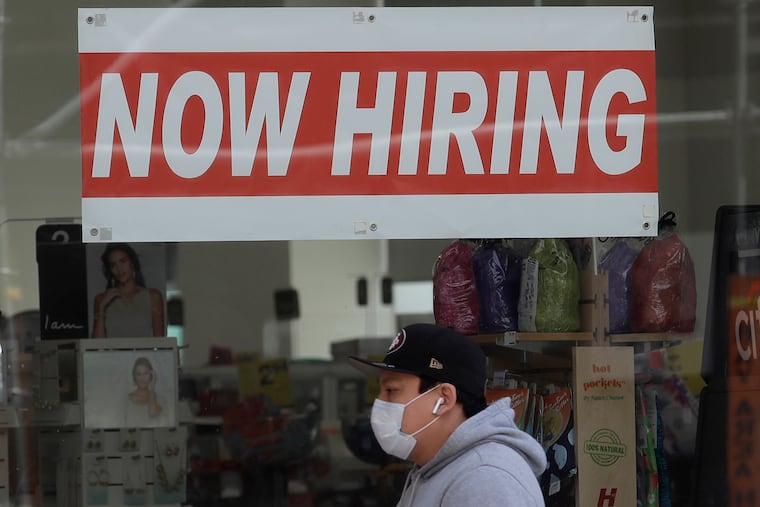 A man wearing a mask while walking under a Now Hiring sign at a CVS Pharmacy during the coronavirus outbreak in San Francisco. On Thursday, Nov. 12, the number of people seeking unemployment benefits fell last week to 709,000, the fourth straight drop and a sign that the job market is slowly healing. The figures coincide with a sharp resurgence in confirmed viral infections to an all-time high above 120,000 a day.
