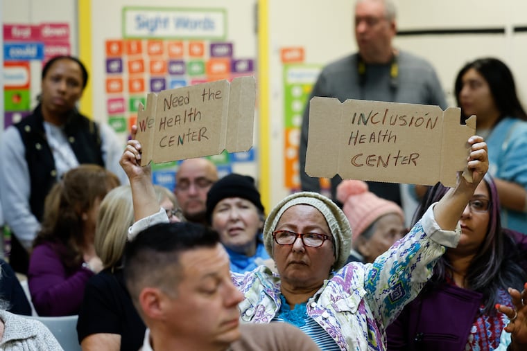 Maria Serna holds a sign in favor of the creation of a health center on the Friends Hospital campus along Roosevelt Boulevard in 2025 during a community meeting at the Simpson Recreation Center on Saturday.