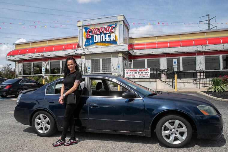 Lisa Mollet, a waitress at Empire Diner, poses for a portrait next to a car that a couple who are customers gave her on Friday, Aug. 21, 2020 in Brooklawn, NJ. The couple heard that she was having car trouble and as a tip gave her the 2006 Nissan Altima.