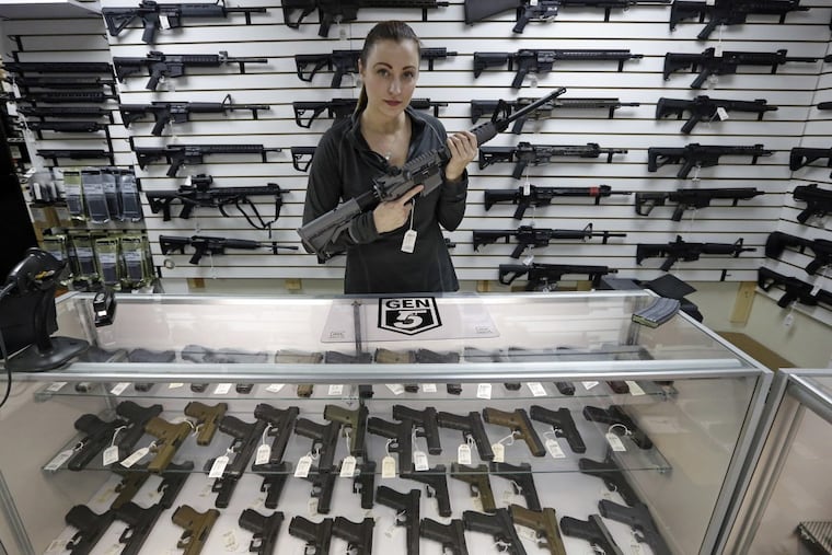 Gun shop owner Tiffany Teasdale-Causer poses for a photo with a Ruger AR-15 semi-automatic rifle, the same model, though in gray rather than black, used by the shooter in a Texas church massacre two days earlier, Tuesday, Nov. 7, 2017, in Lynnwood, Wash.