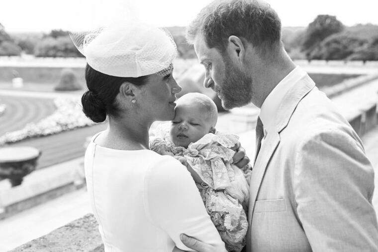 This is an official christening photo released by the Duke and Duchess of Sussex on Saturday, July 6, 2019, showing Britain's Prince Harry, right and Meghan, the Duchess of Sussex with their son Archie Harrison Mountbatten-Windsor at Windsor Castle with with the Rose Garden in the background, in Windsor, England.
