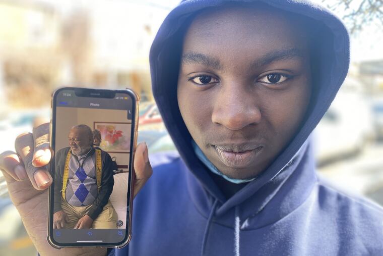Tymire Alston-Haywood, 15, holds a cellphone picture of his great grandfather, James Watson, 69, who was killed in a ATM robbery in March 2022.