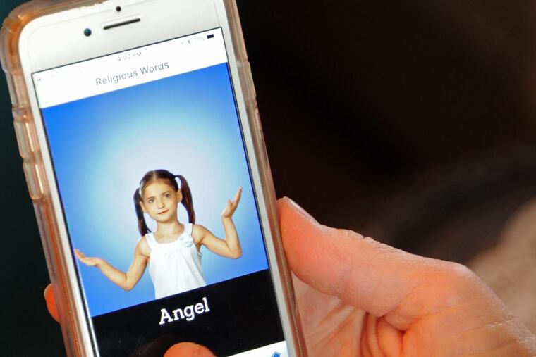 Sister Kathleen Schipani, director of the Deaf Apostolate of the Archdiocese of Philadelphia, demonstrates her app, showing Rachael Pomroy, 8, who is deaf and served as one of the models.