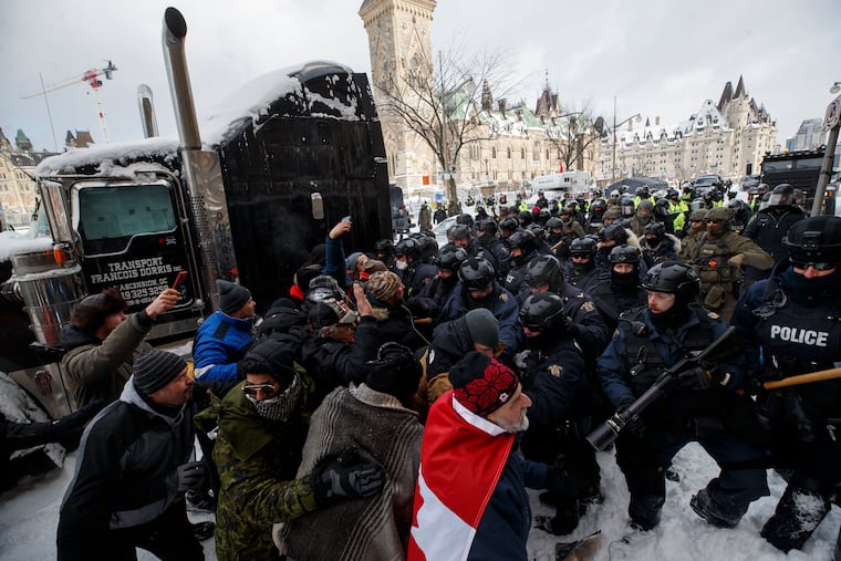Police move in to clear downtown Ottawa near Parliament Hill of protesters on Saturday.
