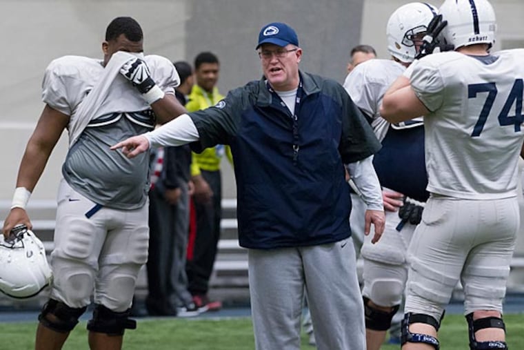 Penn State offensive line coach Herb Hand motions to players.
