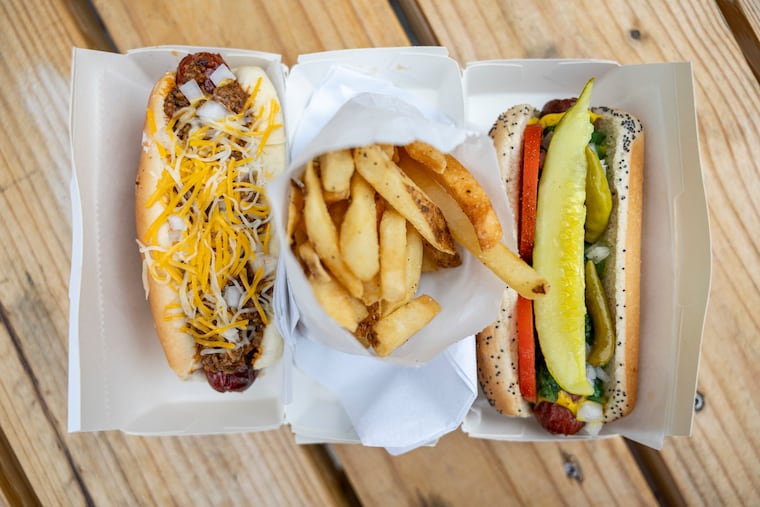 A Chili Cheese Dog and a Chicago Dog with a side of fries from Bad Nina’s grand opening outside Attic Brewing in Philadelphia on Wednesday, July 16, 2025.