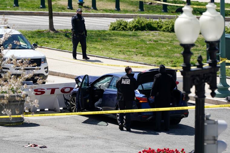 U.S. Capitol Police officers stand near a car that crashed into a barrier on Capitol Hill in Washington.