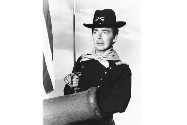 FILE - In a July 1, 1965 file photo, Ken Berry, who plays Captain Wilton Parmenter in a TV series called "F Troop," reaches down the wrong end of cannon in one of the show's episodes. A spokeswoman at Providence St. Joseph in Burbank, Calif., confirmed Berry died Saturday, Dec. 1, 2018. He was 85. (AP Photo, File)