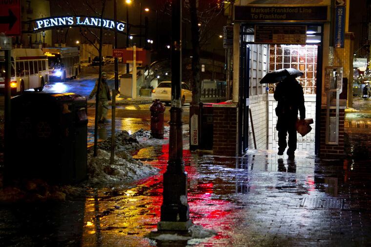 Pedestrians along East Market Street in Old City in the evening rush hour January 8, 2018 cope with a nuisance storm bringing a mix of freezing rain, sleet and snow to the region.