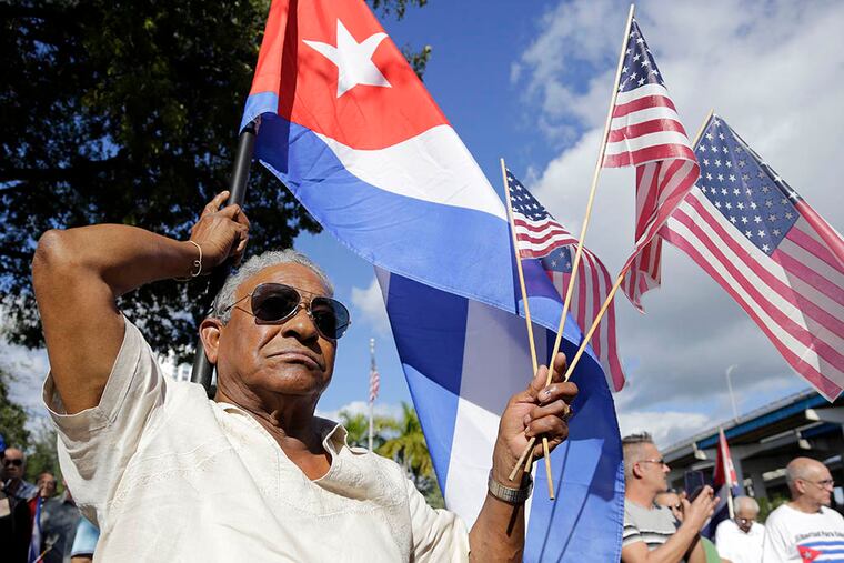 Evilio Ordonez holds Cuban and American flags during a protest in Miami’s Little Havana neighborhood against President Obama’s plan to normalize relations with Cuba. (Associated Press)