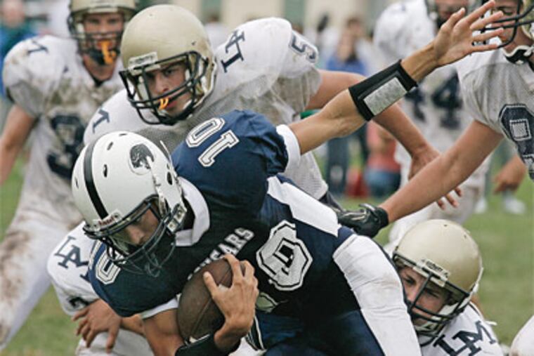 Calvary, QB # 10 Michael Reichenbach is sacked by Lower Moreland Players (left to Right) # 7 Mike Trentalage, #50 Greg Cawood, #64 Mark Lesser at 2nd QT. 09/27/2008 (Akira Suwa / Inquirer )