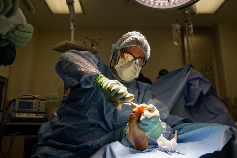 At Pennsylvania Hospital, surgeon Keith Wapner trims the bone in Pattie Bostick-Winn's arthritic big toe before inserting a synthetic implant, called Cartiva, to cushion the joint.