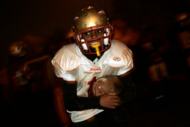Rashaun Williams, 12, carries the ball at an Aztecs practice at Hunting Park. Players must maintain good grades in school and stay out of trouble to be on an Aztecs team.