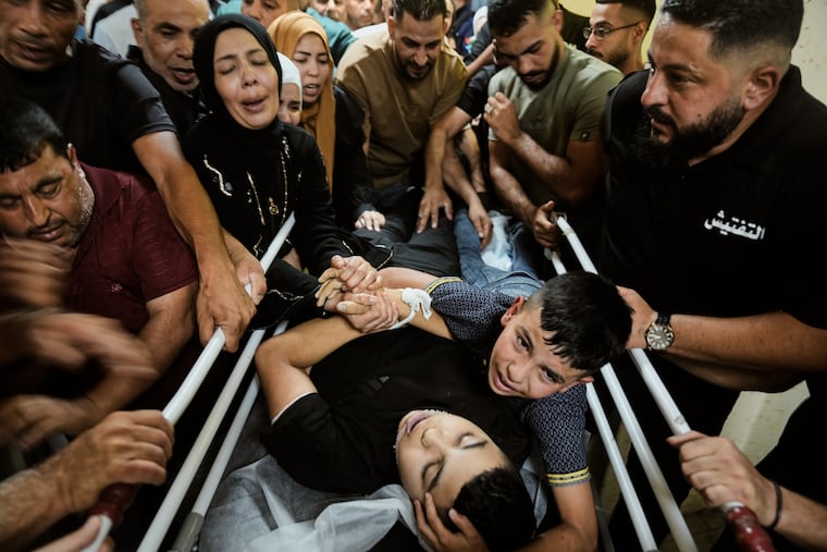 Mohammed Ajouri mourns over the body of his brother Islam Ajouri, 14, who, according to the Palestinian Ministry of Health, was killed by Israeli forces, as his body is brought to the hospital in the West Bank city of Nablus, Sunday, Aug. 23, 2026.