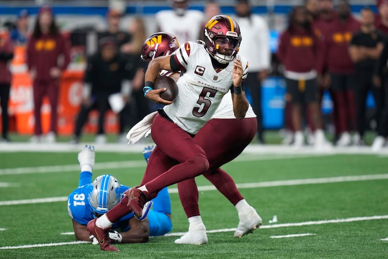 Washington Commanders quarterback Jayden Daniels (5) runs past Detroit Lions defensive end Levi Onwuzurike (91) during the second half.