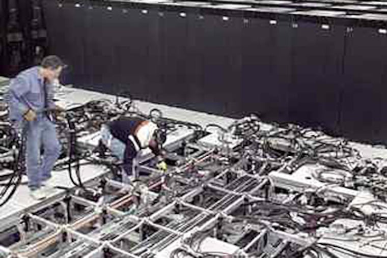 Wiring the Blue Gene supercomputer at Livermore. It helps scientists in "stockpile stewardship," their post-Cold War mission: assessing the reliability of existing weapons without exploding them. (Lawrence Livermore National Laboratory)