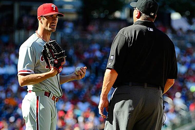 Phillies starting pitcher Cole Hamels discusses a call with umpire Chad Fairchild. (Brad Mills/USA TODAY Sports)