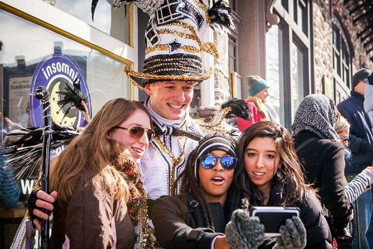 Selfie with a strutter: Revelers and a string band member last year at Mummers Mardi Gras in Manayunk.