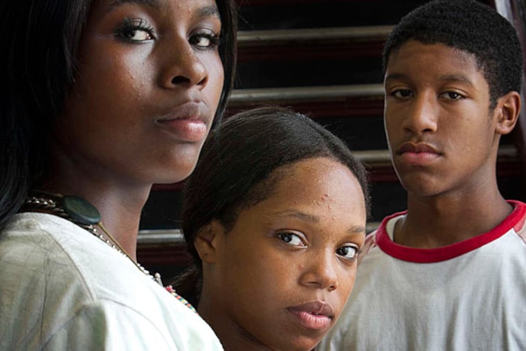 These youngsters had Trayvon Martin on their minds, but others (right) were focused yesterday on slain teen Tremaine Rogers.