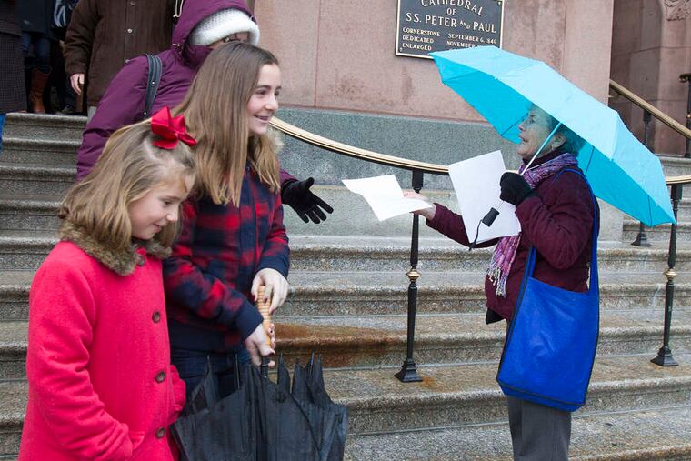 Judy Miller hands out leaflets at the Cathedral Basilica of SS. Peter and Paul. She and her husband are upset by the ruling that reversed Msgr. William J. Lynn's child-endangerment conviction.