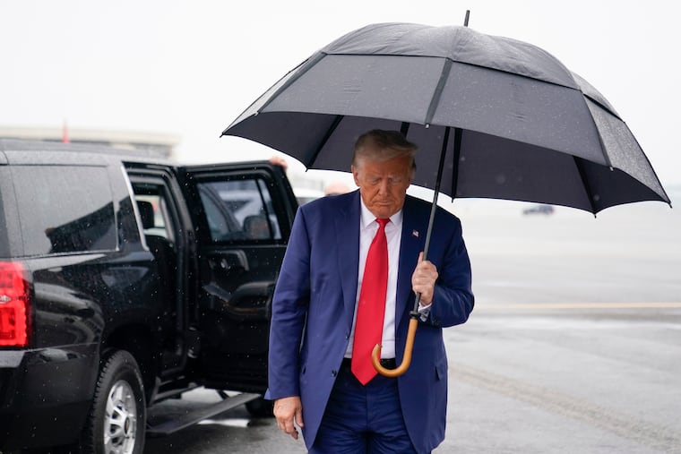 Former President Donald Trump walks over to speak with reporters before he boards a plane at Ronald Reagan Washington National Airport in Arlington, Va. Thursday.