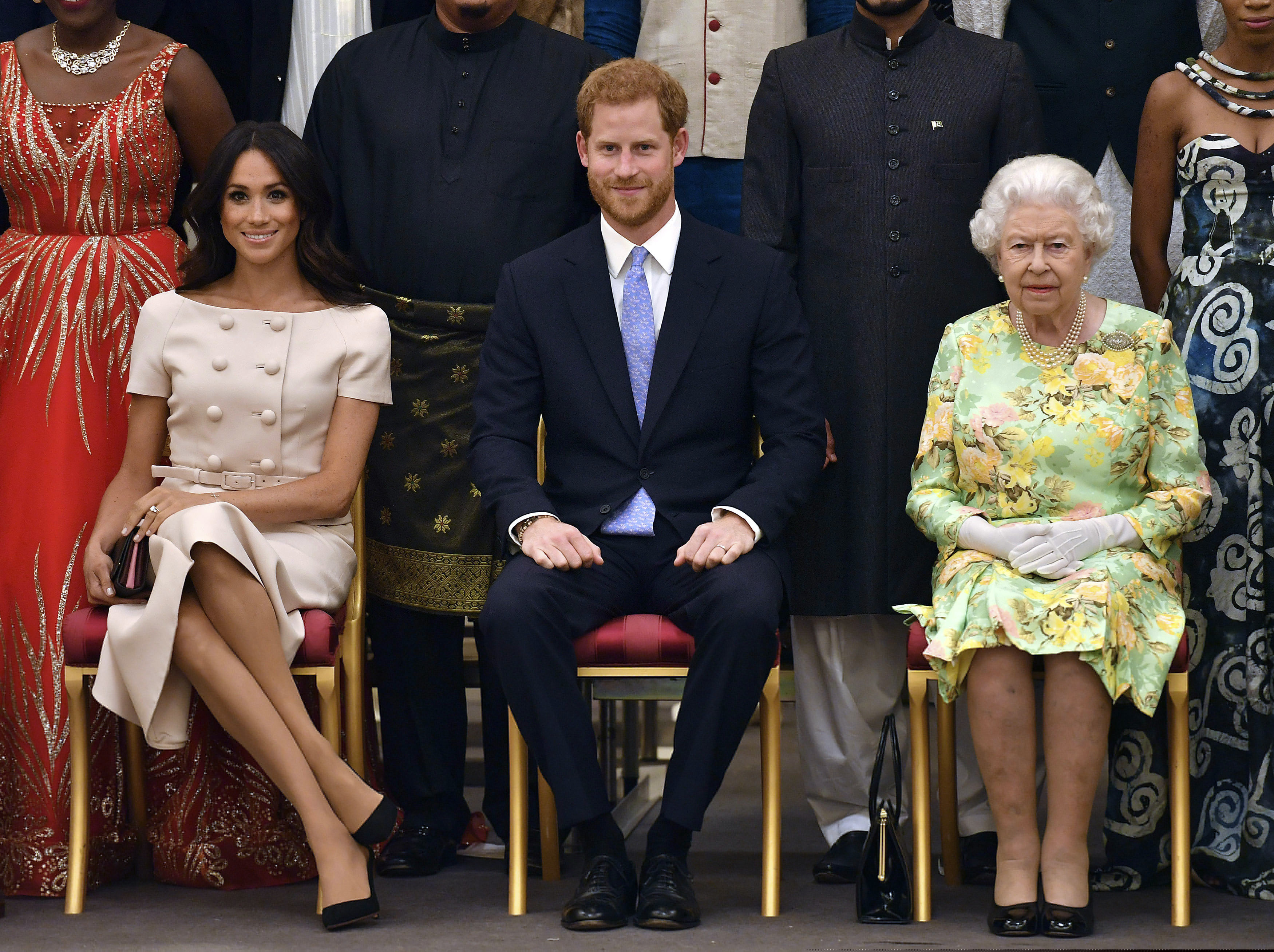 In this Tuesday, 2018 file photo Britain's Queen Elizabeth, Prince Harry and Meghan, Duchess of Sussex pose for a group photo at the Queen's Young Leaders Awards Ceremony at Buckingham Palace in London. In a stunning declaration, Britain's Prince Harry and his wife, Meghan, said they are planning "to step back" as senior members of the royal family and "work to become financially independent."