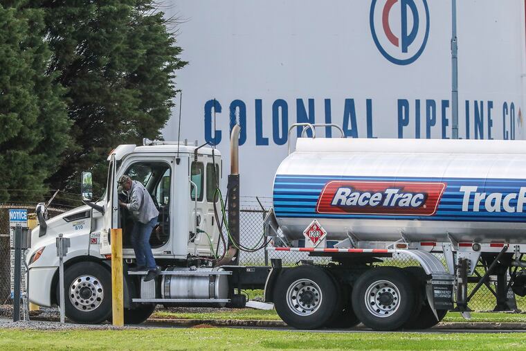 Gasoline tankers pass by the Colonial Pipeline storage tanks in Austell, Georgia, on Monday, May 10, 2021, as they enter the Marathon Powder Springs Terminal. A ransomware attack shut down the Alpharetta-based Colonial Pipeline that delivers roughly 45% of fuel consumed on the East Coast. (John Spink/The Atlanta Journal-Constitution/TNS)