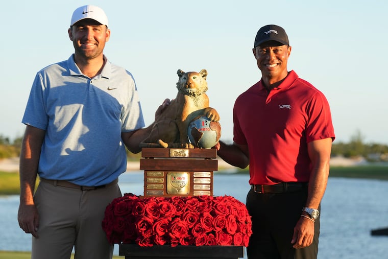 Scottie Scheffler (left) and Tiger Woods pose with the trophy after Scheffler won Woods' Hero World Challenge. That money does not count toward Scheffler's career winnings; he's third behind Woods and Rory McIlroy but could soon pass them both.