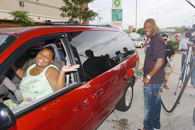 Brenda Thomas of South Philadelphia is all smiles as hometown boxing champion Bernard Hopkins pumps $50 worth of free gas into her car.