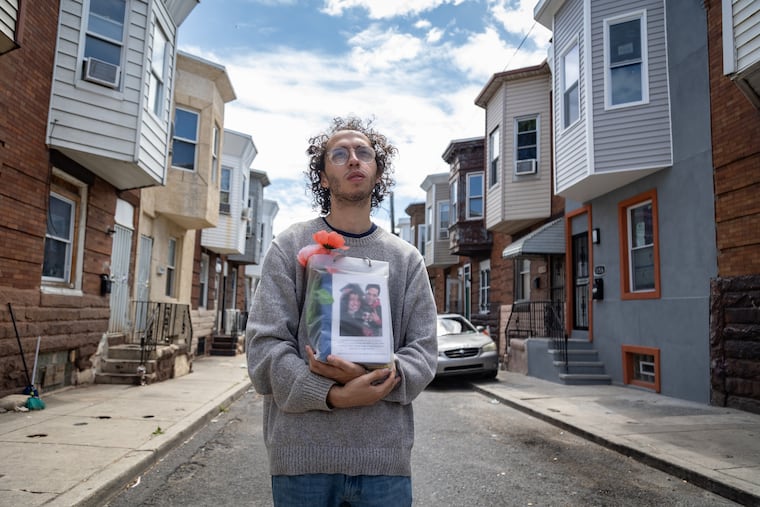 Guillermo Santos Jr. holds the ashes of his father, Guillermo Santos Sr., who died of a fentanyl overdose in 2021, outside his childhood home near Kensington and Allegheny Avenues in August.