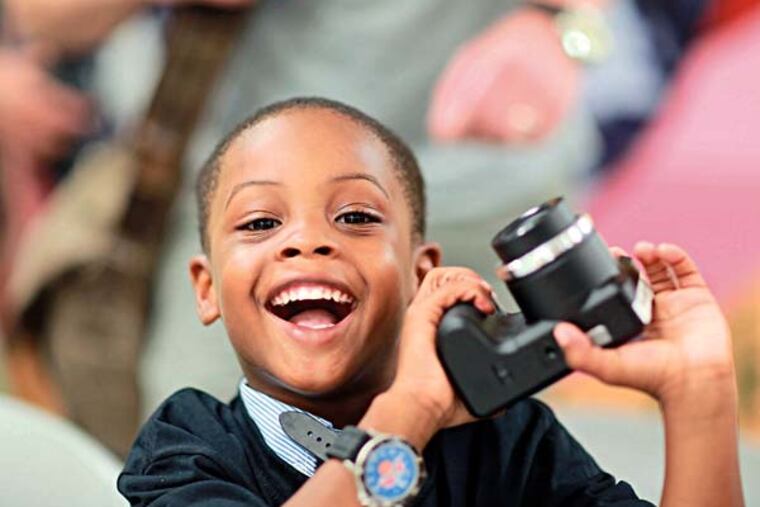 Tae'marr Tubbs, 5, is thrilled with a new camera. Photojournalist and author Linda Soloman will host a workshop for homeless children living in the Drueding Center Thursday June 26, 2014. ( DAVID SWANSON / Staff Photographer )