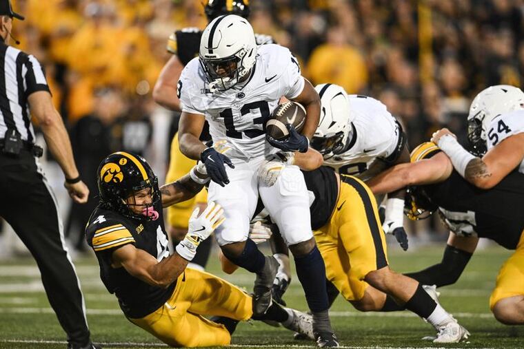 Penn State's Kaytron Allen (13) runs the ball as Iowa defensive back Koen Entringer (4) and linebacker Jayden Montgomery (36) attempt a tackle during their game on Saturday night.