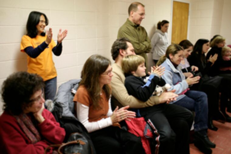From the back of the room, Bobbi Wolf, founder of the Wolf Performing Arts Center, joins parents and friends in applauding a children's performance of "The Very Busy Spider." The Wolf Center is run out of Wynnewood's Church of the Holy Apostles.