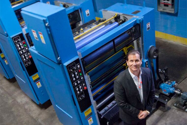 Nicholas Maiale, president and CEO of Inserts East Inc. in Pennsauken, with his company's eight-unit press. He's thinking of adding another production line. (David M Warren / Staff Photographer)