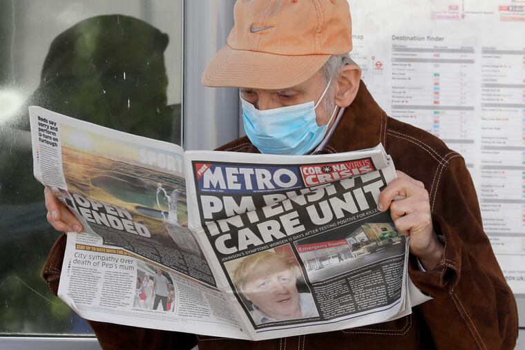 A man reads a newspaper with the headline: 'PM in intensive care', outside St Thomas' Hospital in central London as British Prime Minister Boris Johnson is in intensive care fighting the coronavirus.