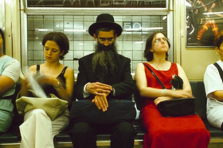 Fitting in, a Hasidic Jew with fellow commuters on a New York subway - from the documentary, "The Jewish Americans."
