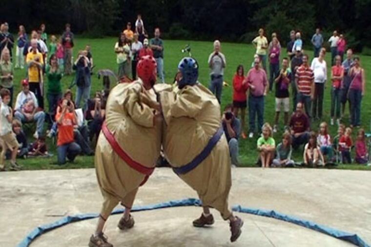 Republican Lansdale Mayor Andy Szekely (left) and Democratic challenger Ben Gross take out their political differences in a sumo-wrestling match while raising money for Manna on Main Street, a local charity. (Ron Tarver / Staff Photographer)