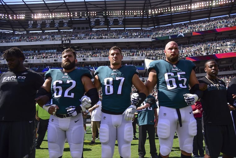 Eagles players Jason Kelce (left), Brent Celek and Lane Johnson hook arms during the playing of the national anthem before the game against the Giants at Lincoln Financial Field Sept. 24, 2017. The Eagles won, 27-24.
