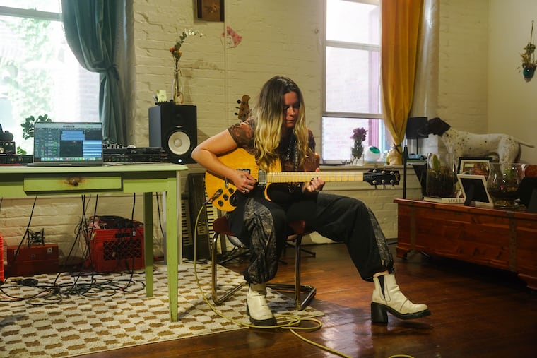 Zoe Tanner practices guitar in the living room of her apartment in Olde Kensington.