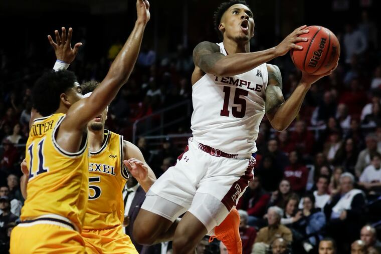 Temple guard Nate Pierre-Louis drives to the basket after getting fouled by Drexel guard Zach Walton (center) and guard Damian Dunn (left) during the second half.