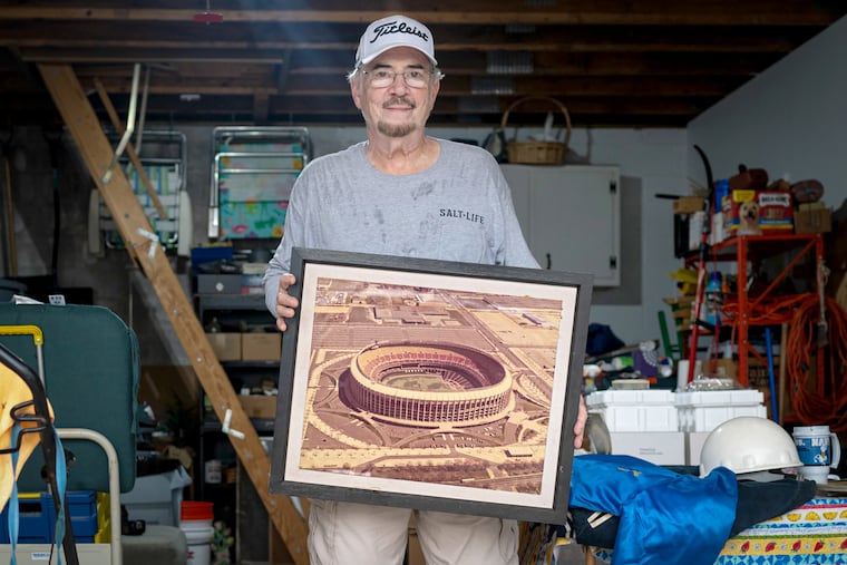 Greg Grillone holds a photo of the Vet, among the memorabilia the stadium's former director keeps at his home in Delaware County.