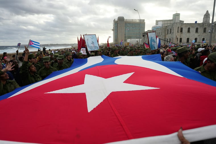 People carry a Cuban flag during a government-organized rally protesting the killing of Cuban officers in Venezuela while U.S. forces captured Venezuelan President Nicolas Maduro and his wife, in Havana, Cuba, Friday, Jan. 16, 2026.