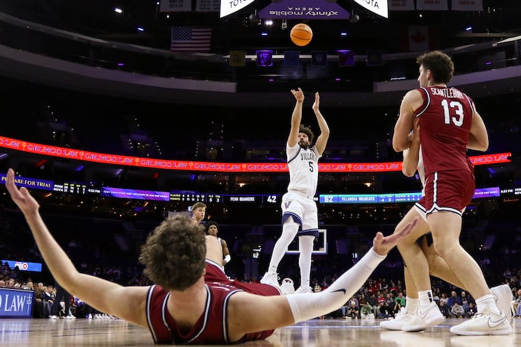 Villanova guard Devin Askew (5) shoots a three-point basket as Penn forward TJ Power (12) reacts during the second half of the Big 5 Classic championship at Xfinity Mobile Arena on Saturday.