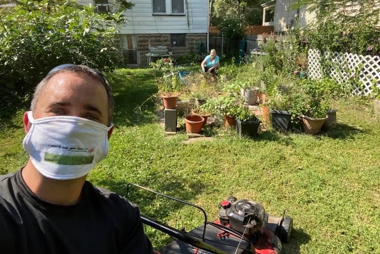 Brian Schwartz, foreground, mows the lawn of Lois Reichert, background, in West Orange, N.J.