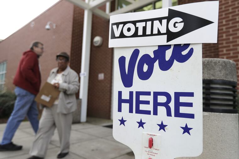 A voter arrives as a worker walks past during early voting at a polling place in Charlotte, N.C., in late October.