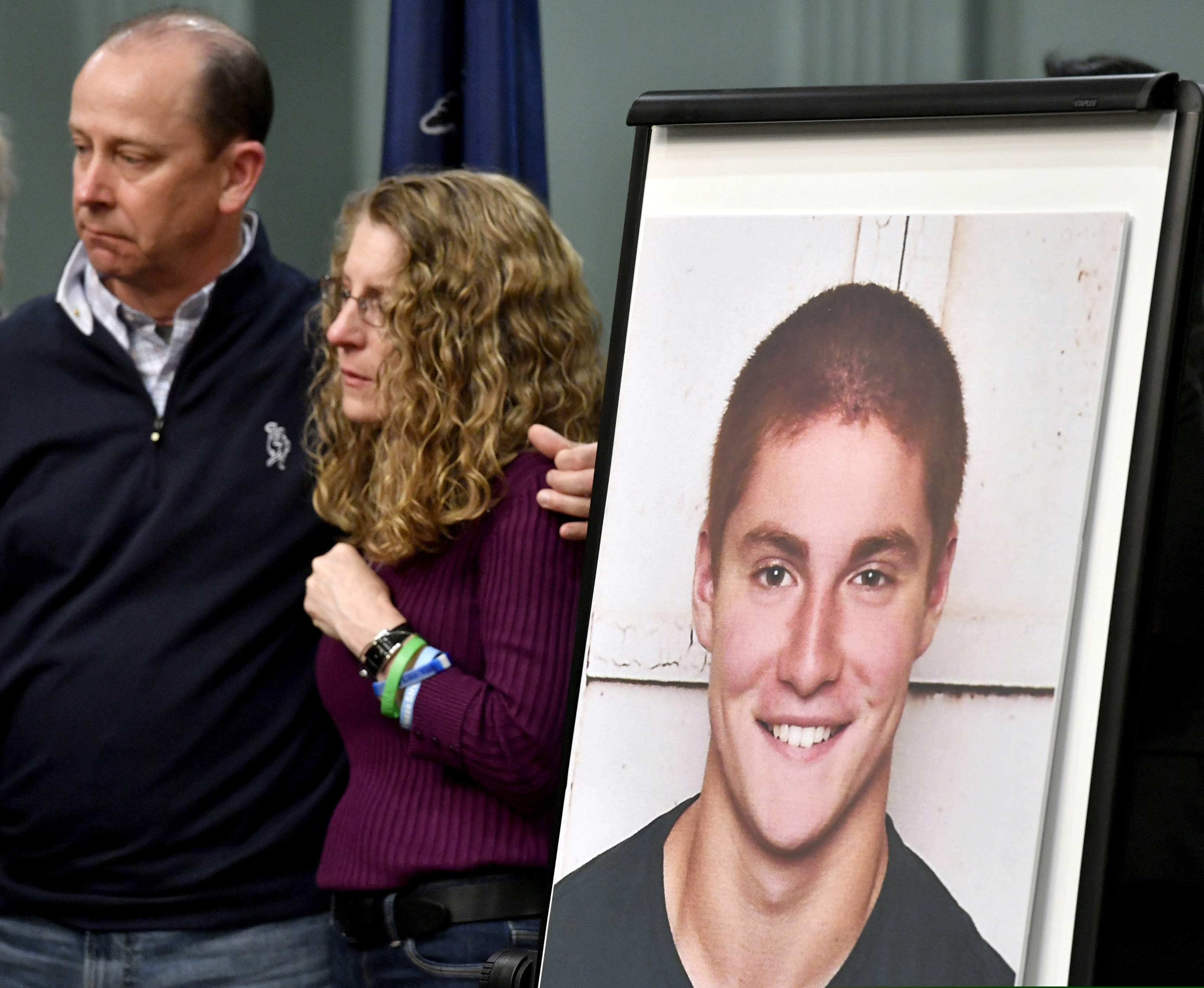 In this May 5, 2017 photo, Jim and Evelyn Piazza, left and center, stand by as Centre County, Pa., prosecutors discuss an investigation into the hazing death of their son Tim Piazza at Penn State.