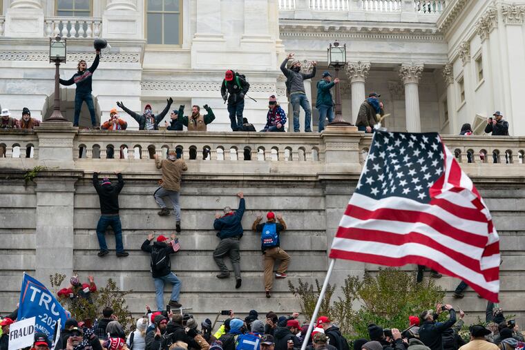 Rioters scaling a wall at the U.S. Capitol on Jan. 6, 2021.